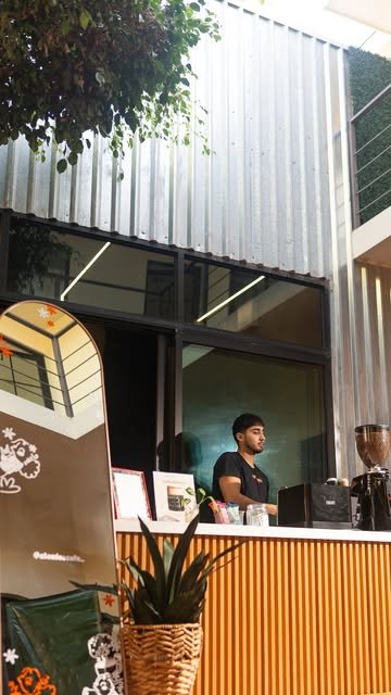 Barista en la barra móvil del coffee cart de Atómico, con molino y frente de madera