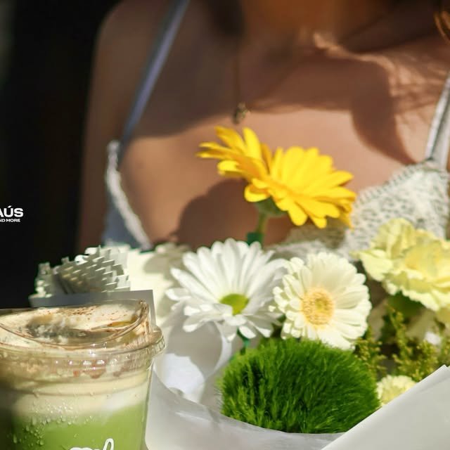 Iced matcha junto a un ramo de gerberas amarillas y blancas de Narciso Flour