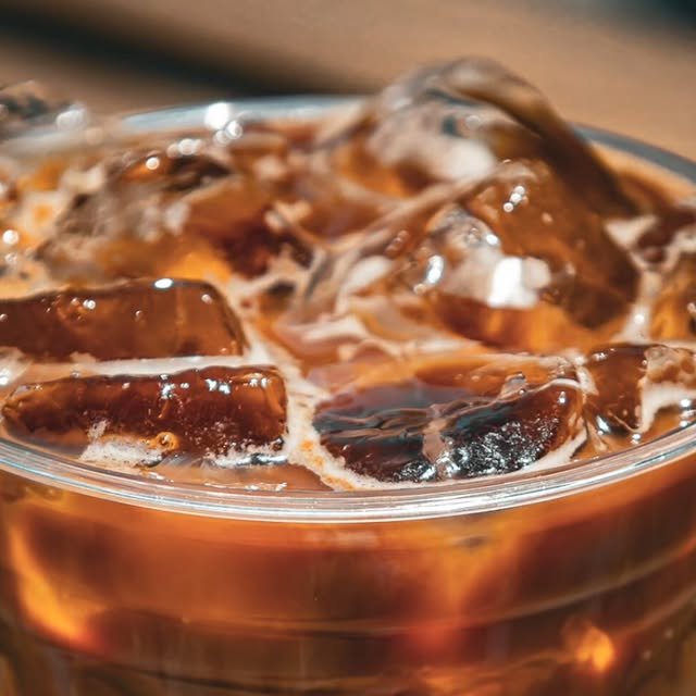Hielo y café frío en vaso de vidrio, vista muy de cerca