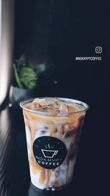 Latte frío con vetas de café en vaso con sticker de Nokrypt Coffee